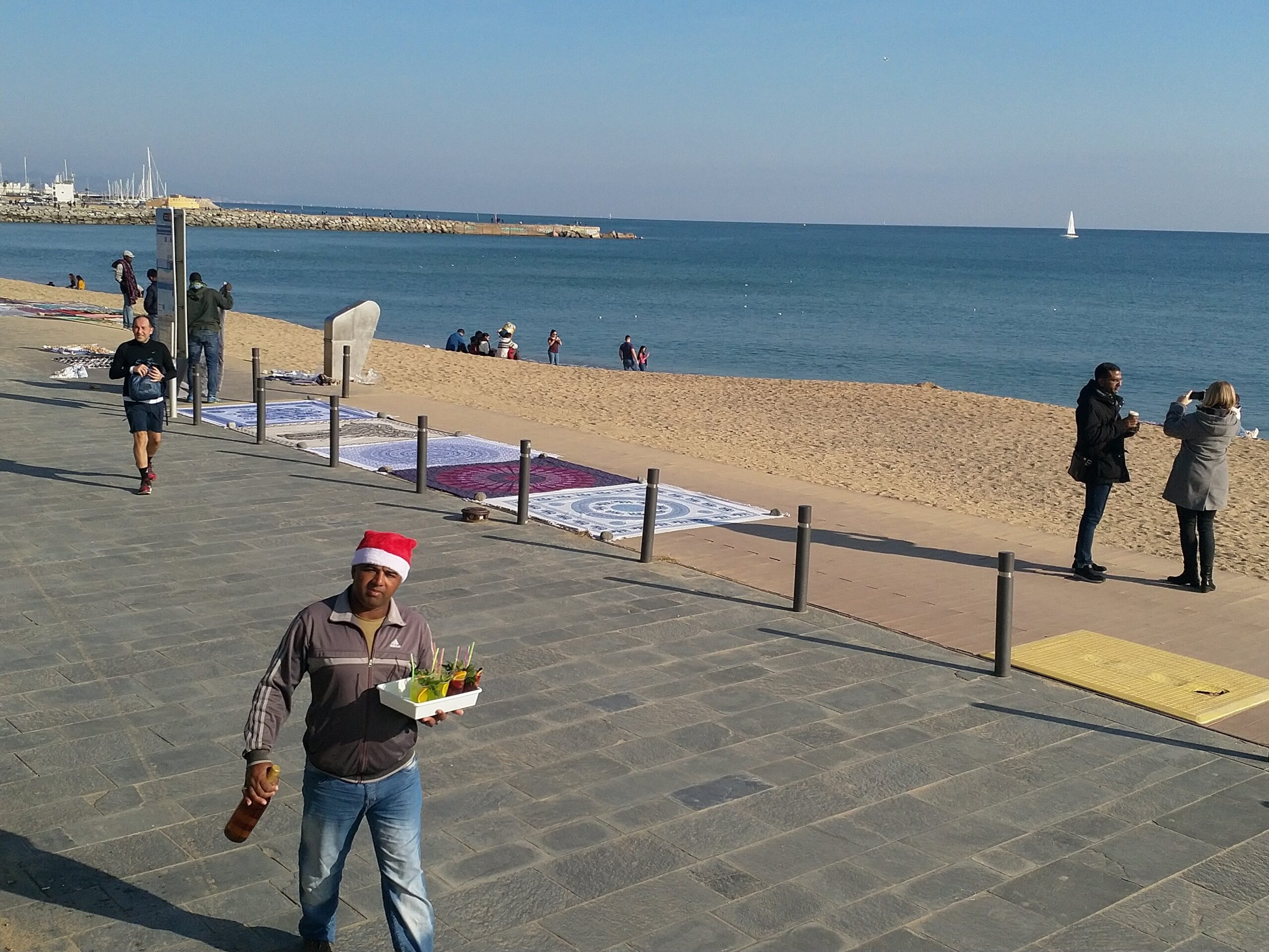 barceloneta beach with a man selling majitos in a christmas hat