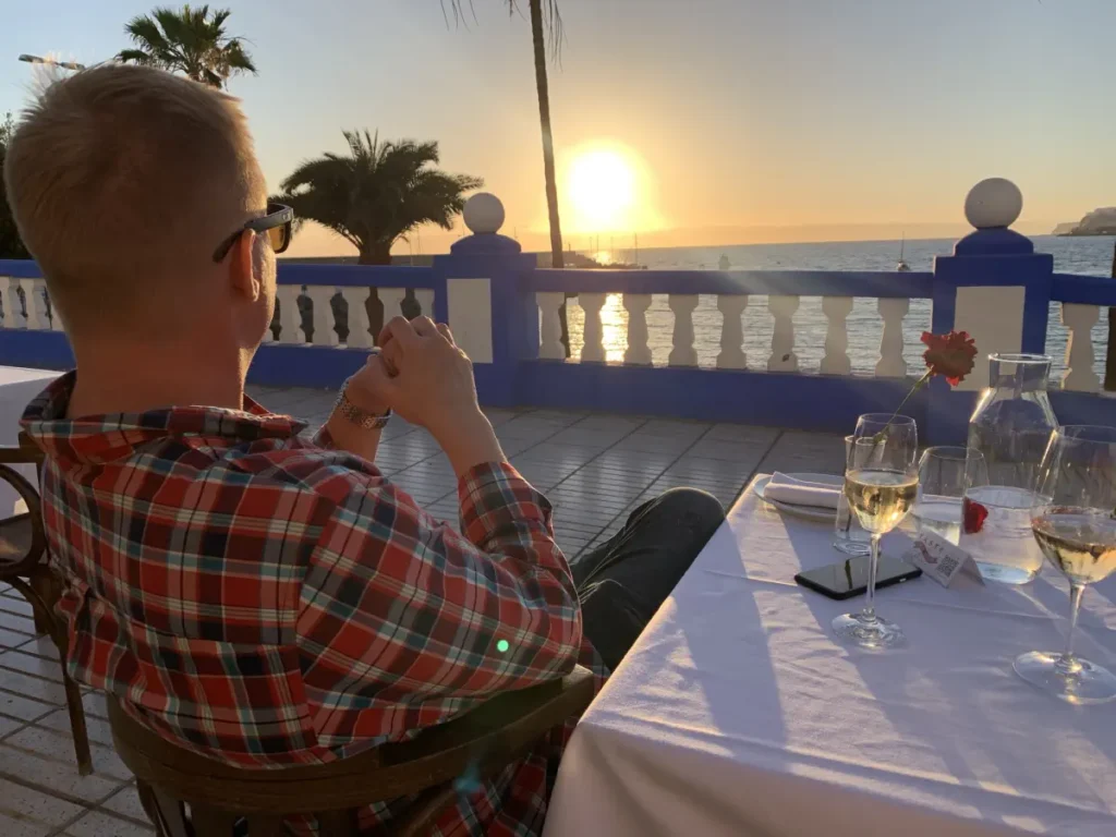 man on a terrace looking into the sunset